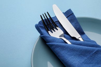 Photo of Beautiful table setting on light blue background, closeup. Space for text