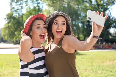 Young women taking selfie outdoors on sunny day