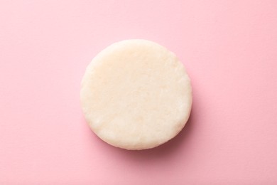 Photo of Solid shampoo bar on pink background, top view