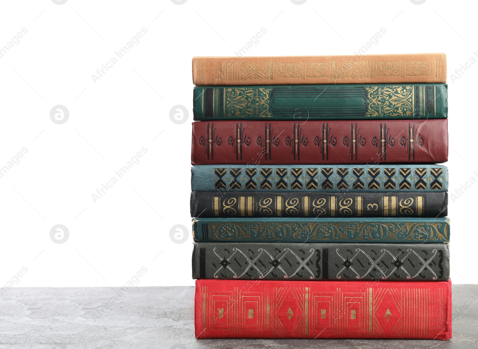 Photo of Stack of old vintage books on grey stone table against white background