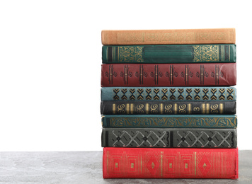 Photo of Stack of old vintage books on grey stone table against white background