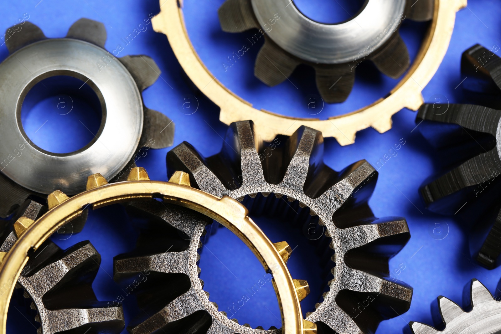 Photo of Different stainless steel gears on light blue background, closeup