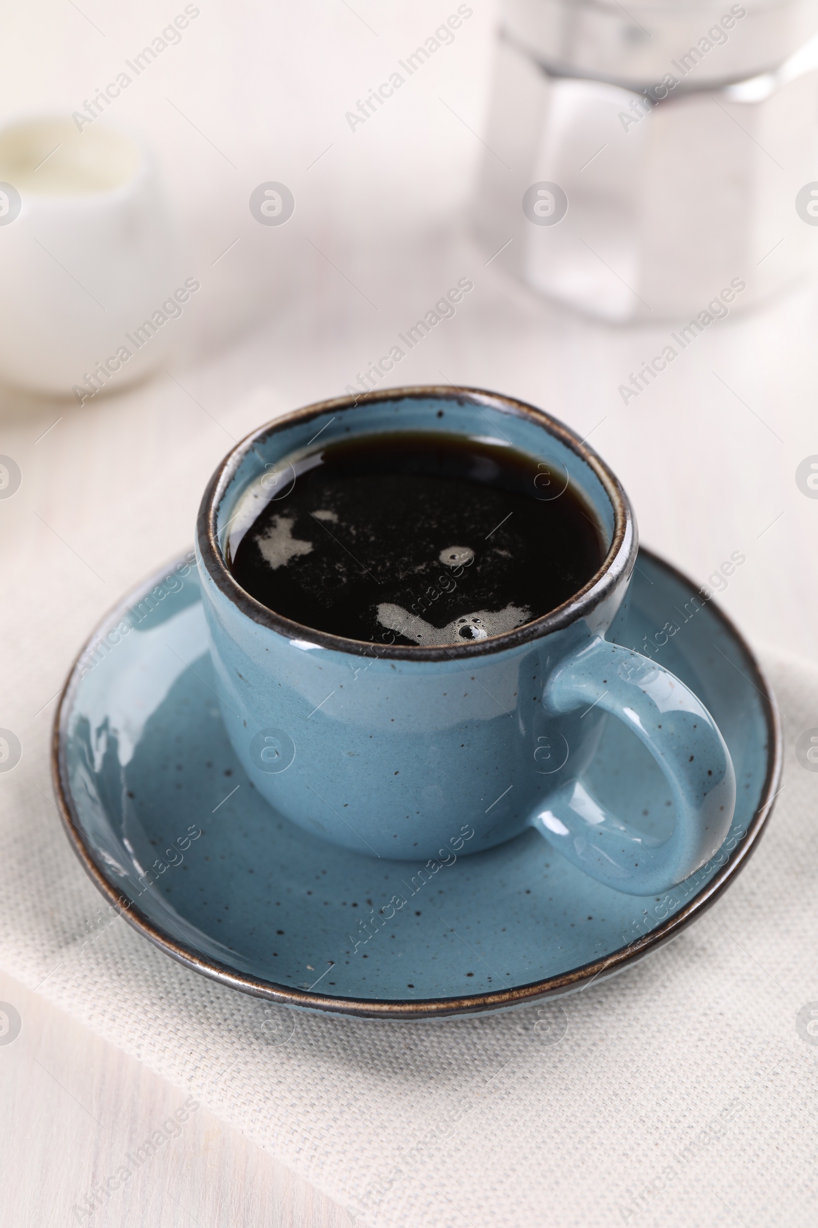 Photo of Delicious coffee in cup on white wooden table