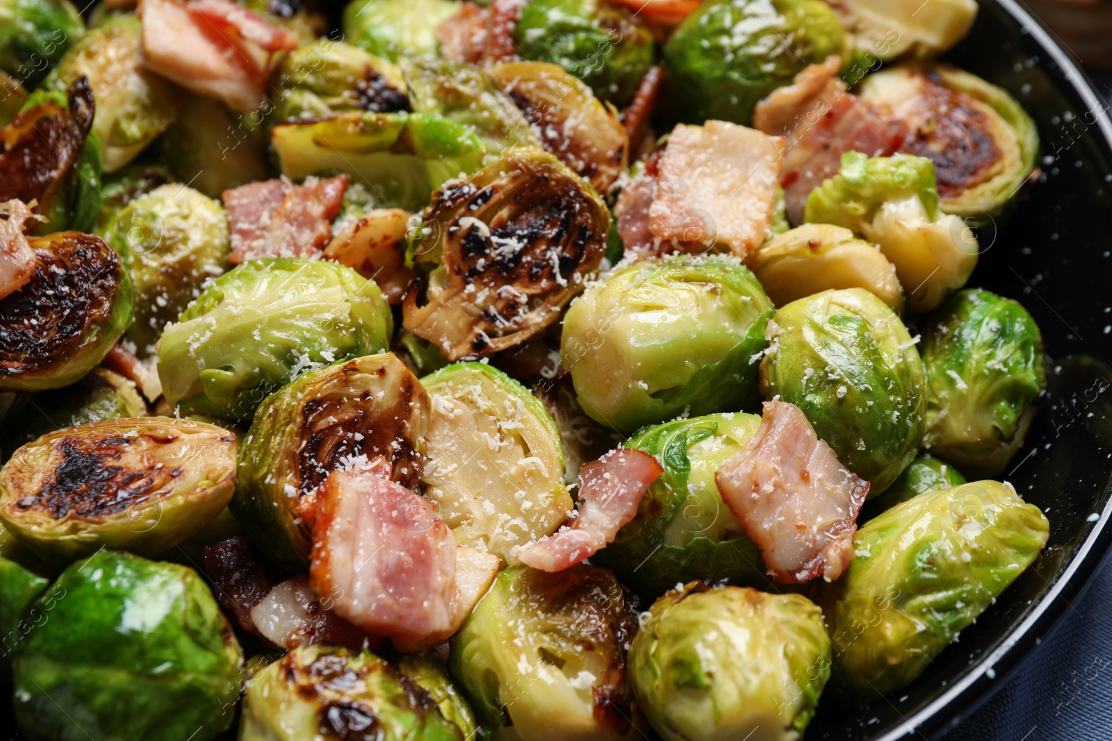 Photo of Delicious Brussels sprouts with bacon in pan, closeup