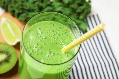 Photo of Tasty fresh kale smoothie on table, closeup