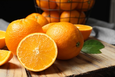 Photo of Wooden board with ripe oranges on table, closeup