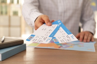 Photo of Travel agent with tickets at table in office, closeup