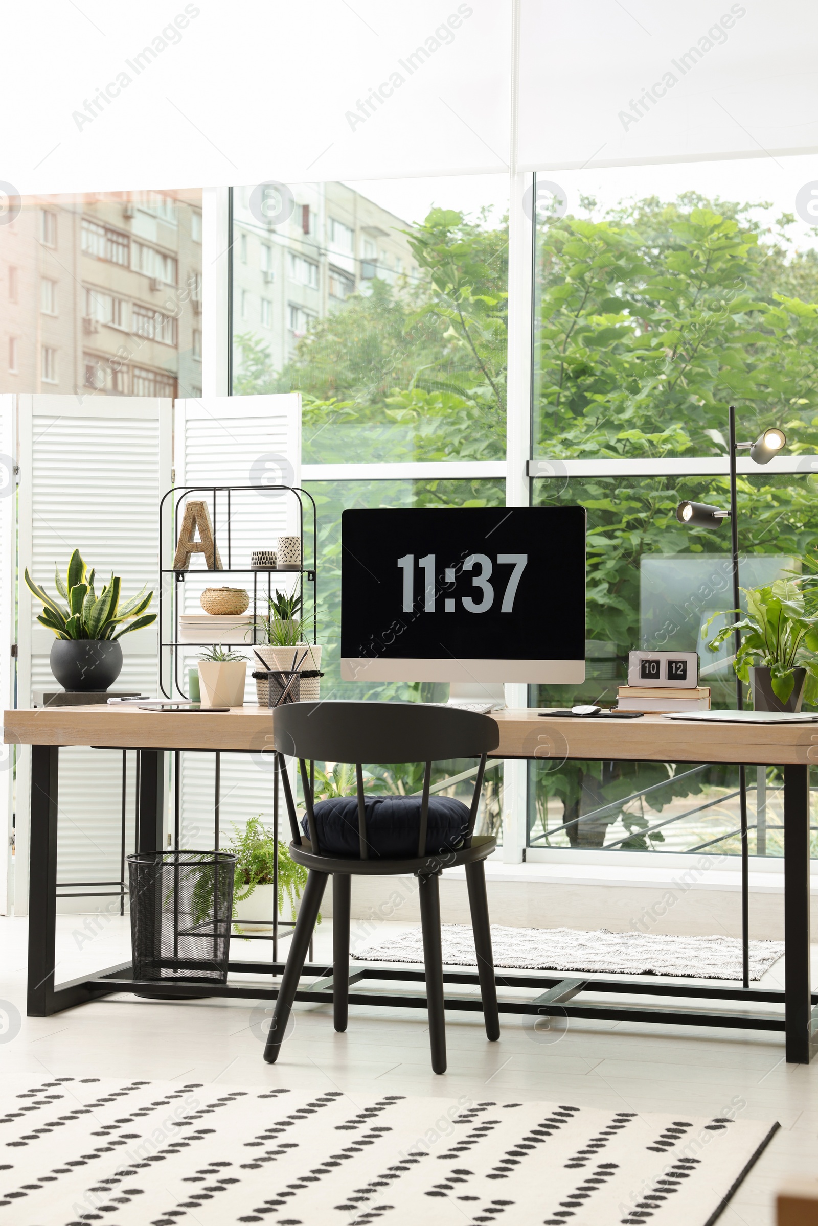 Photo of Comfortable workplace with computer in light room. Interior design