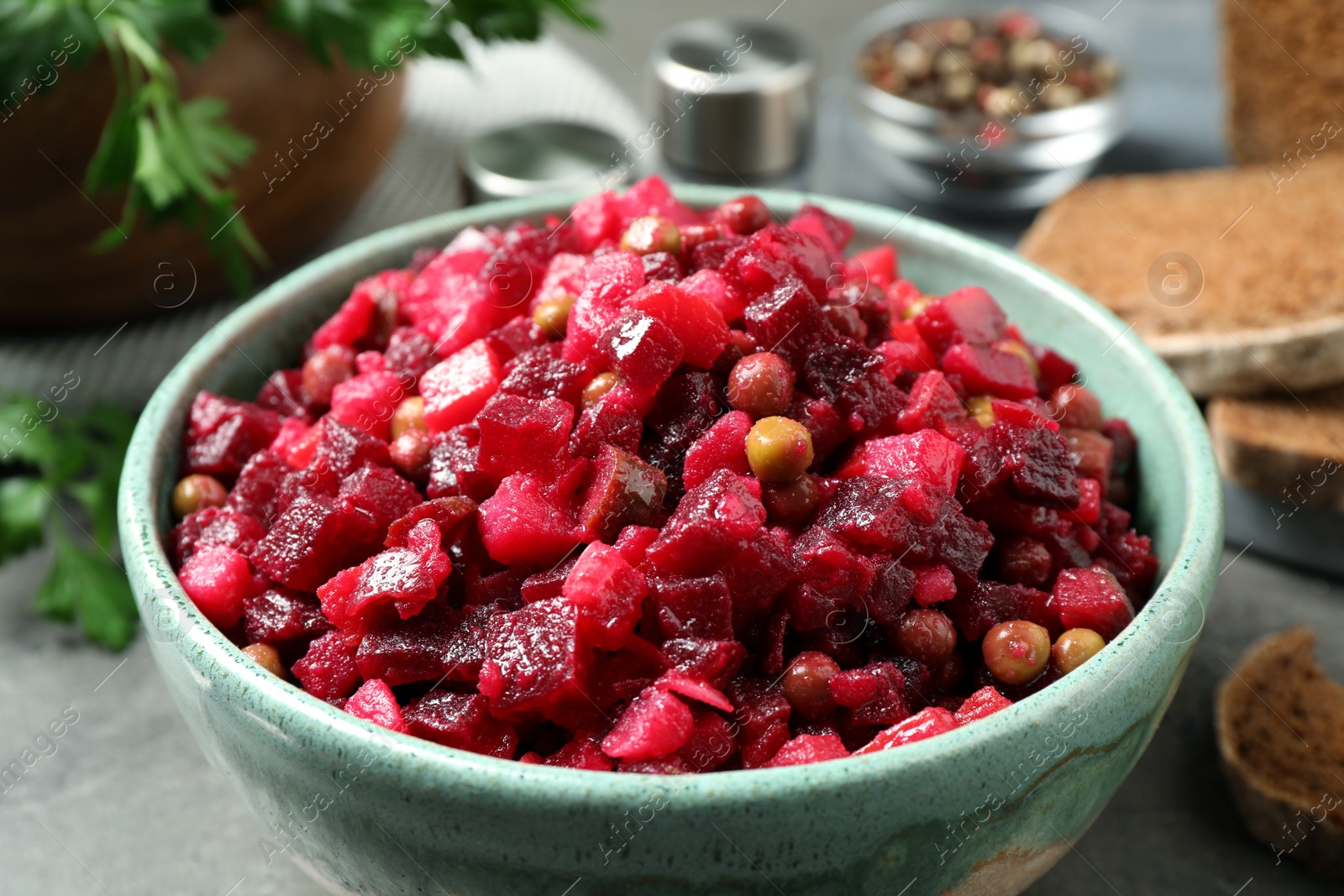 Photo of Traditional Russian salad vinaigrette on grey table, closeup