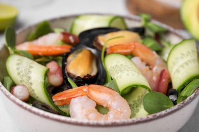 Bowl of delicious salad with seafood, closeup view