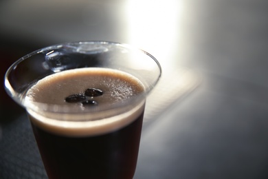 Photo of Glass of martini espresso cocktail in bar, closeup. Space for text