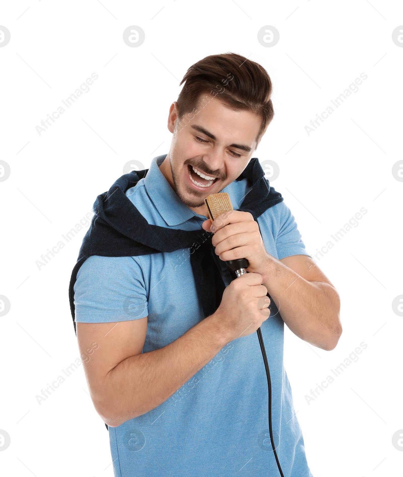 Photo of Young handsome man in casual clothes singing with microphone on white background