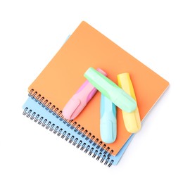 Notebooks and markers isolated on white, top view. School stationery