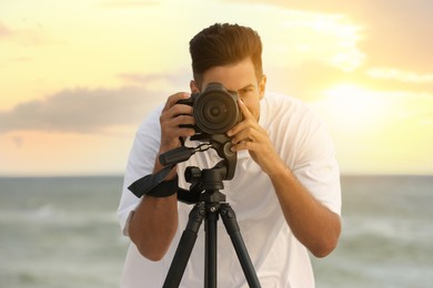 Photo of Photographer working with professional camera near sea
