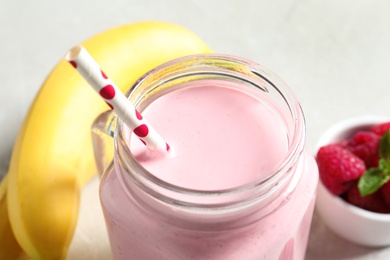 Image of Freshly made raspberry smoothie in mason jar on table, closeup
