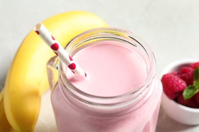 Freshly made raspberry smoothie in mason jar on table, closeup