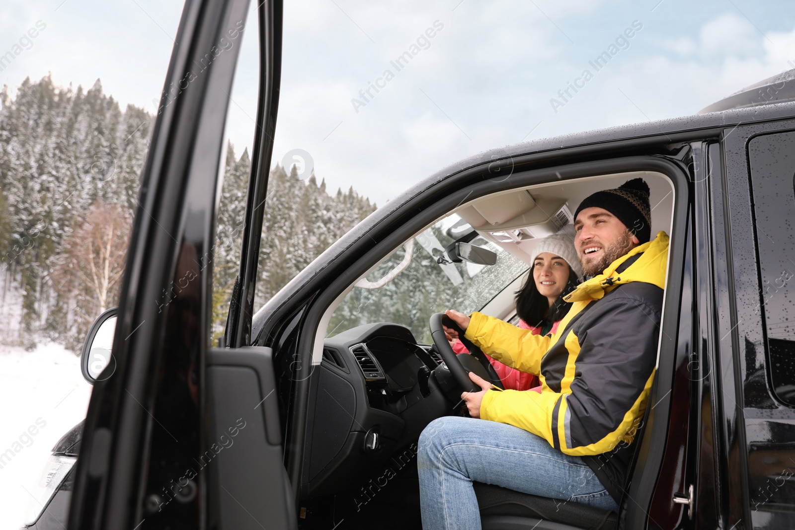 Photo of Happy couple in car outdoors. Winter vacation