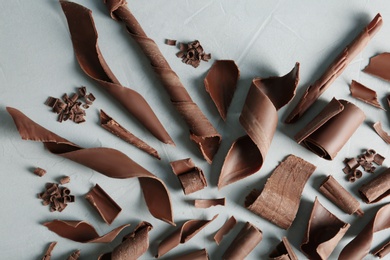 Milk chocolate curls on gray background, top view