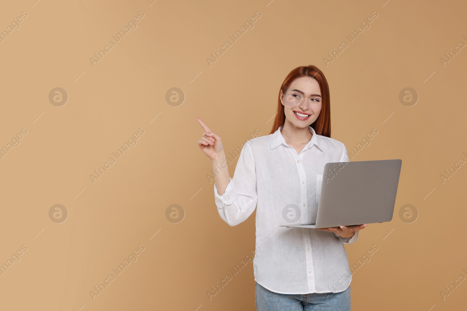 Photo of Smiling young woman with laptop on beige background, space for text