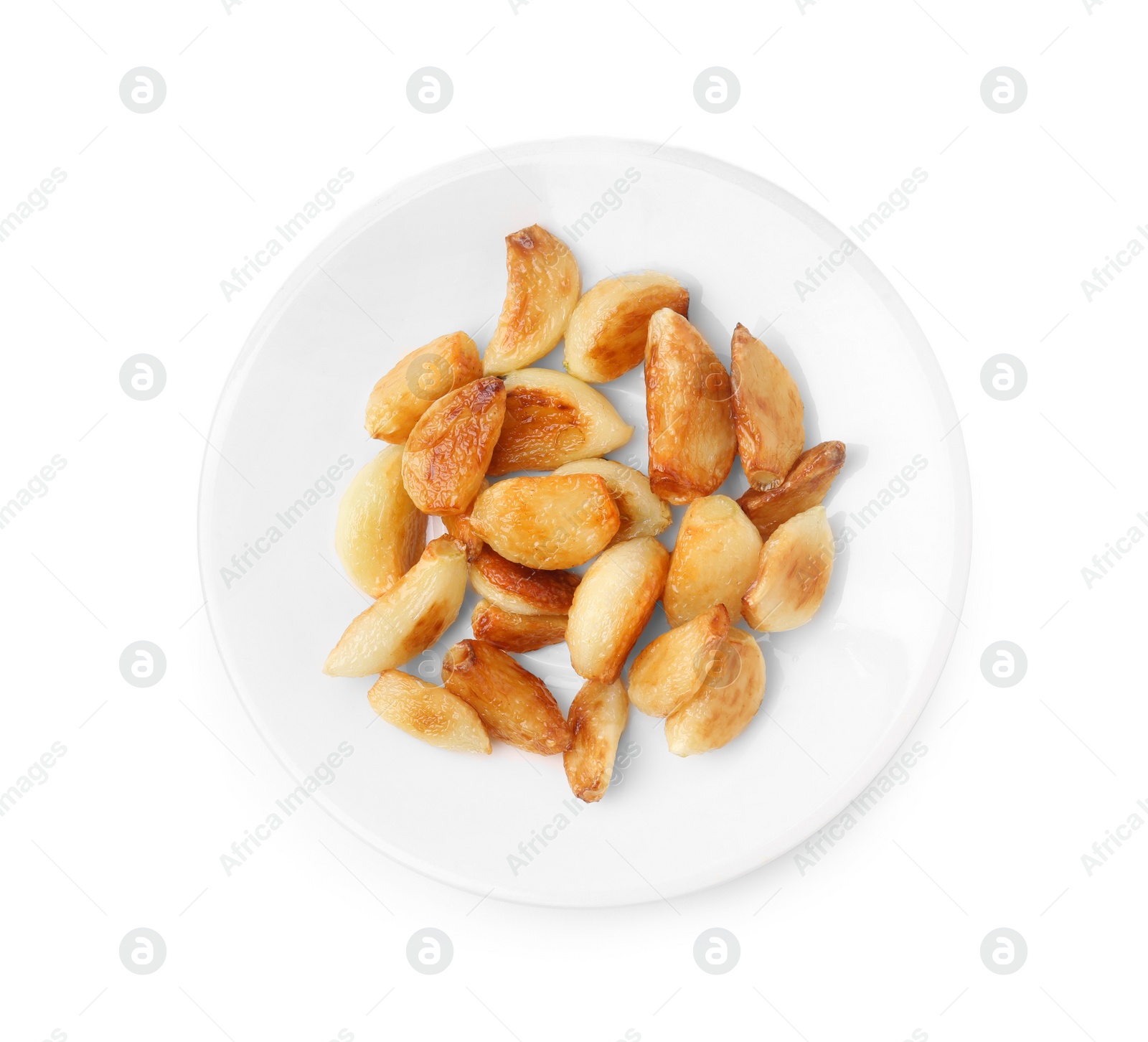 Photo of Plate of fried garlic cloves isolated on white, top view