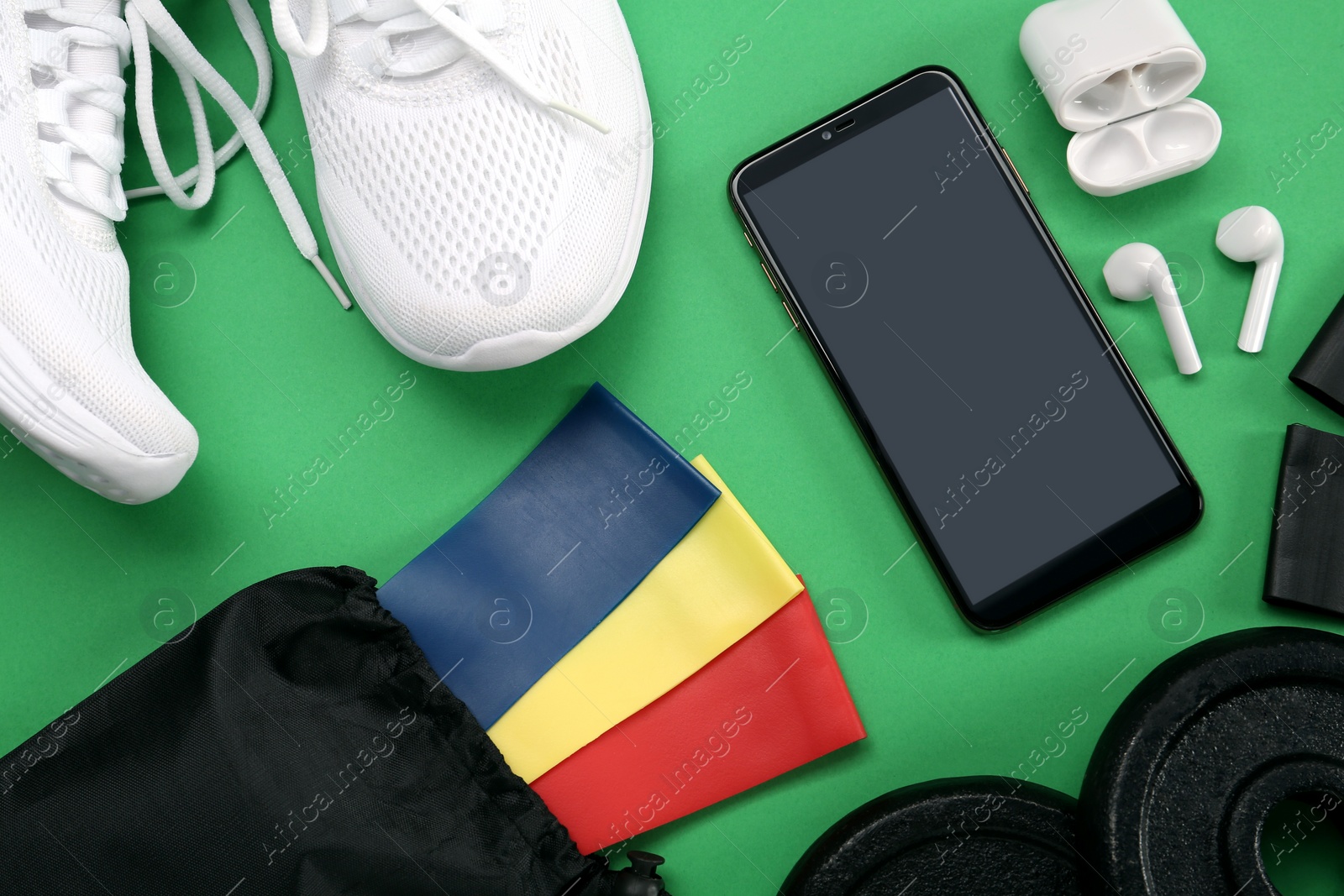 Photo of Flat lay composition with fitness elastic bands on green background