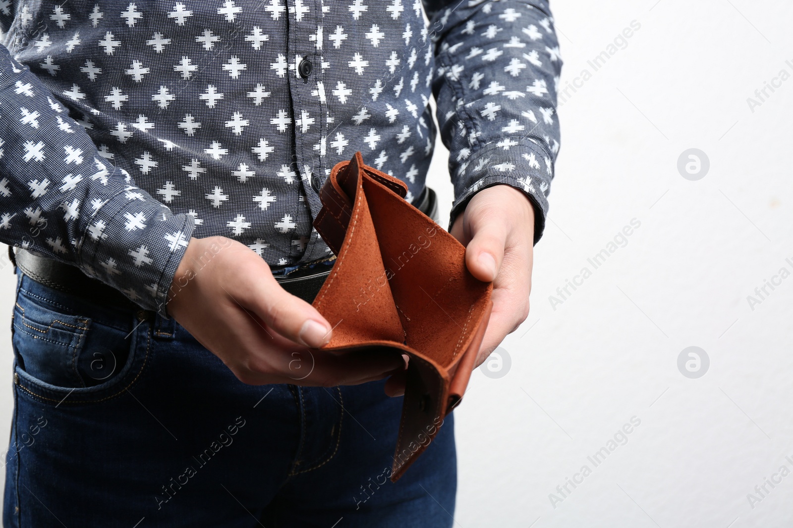 Man showing empty wallet on light background, closeup Photo of Man showing empty wallet on light background, closeup