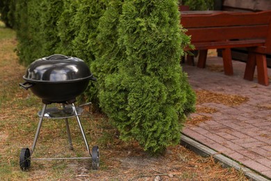 Photo of New barbecue grill near green trees in garden