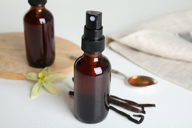 Aromatic homemade vanilla extract on white table, closeup