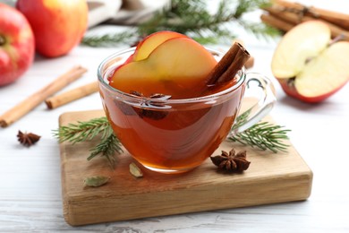 Photo of Aromatic hot mulled cider on white wooden table