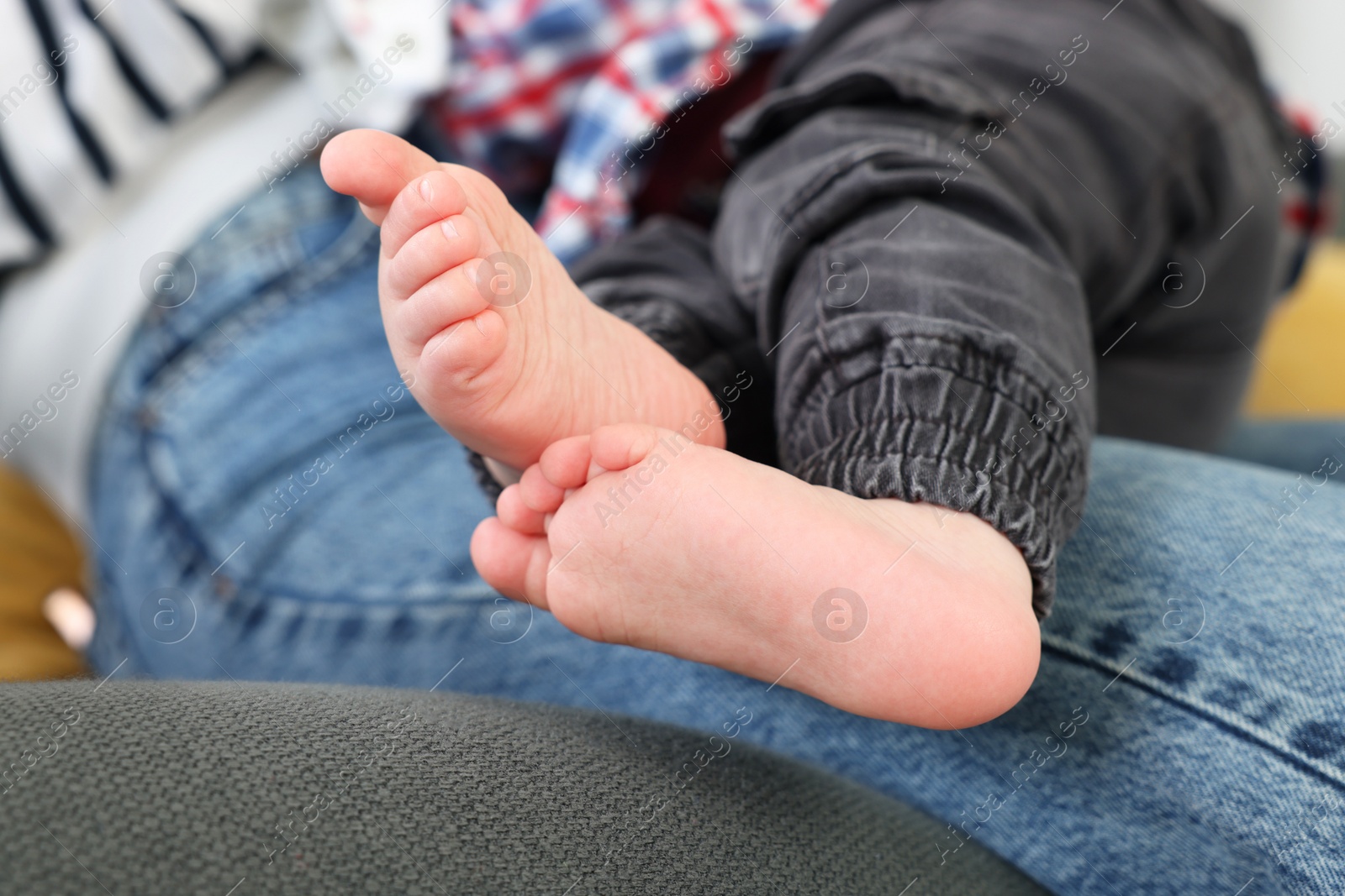 Photo of Mother resting with her son on soft sofa, closeup