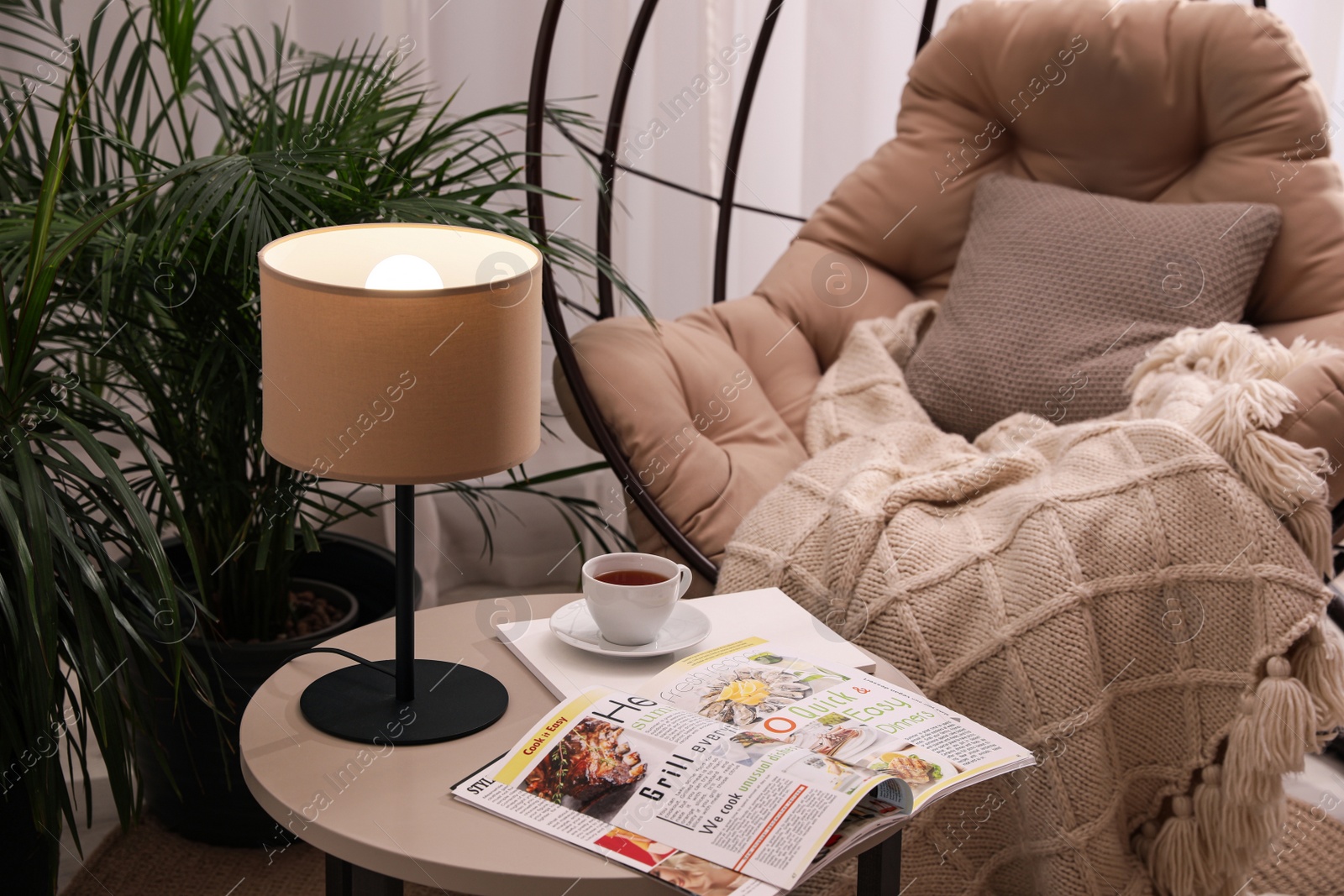 Photo of Comfortable place for rest with hanging chair in room