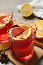 Photo of Aromatic punch drink and ingredients on light grey table