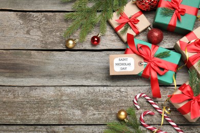 Photo of Saint Nicholas Day. Gift boxes and festive decor on wooden table, flat lay with space for text