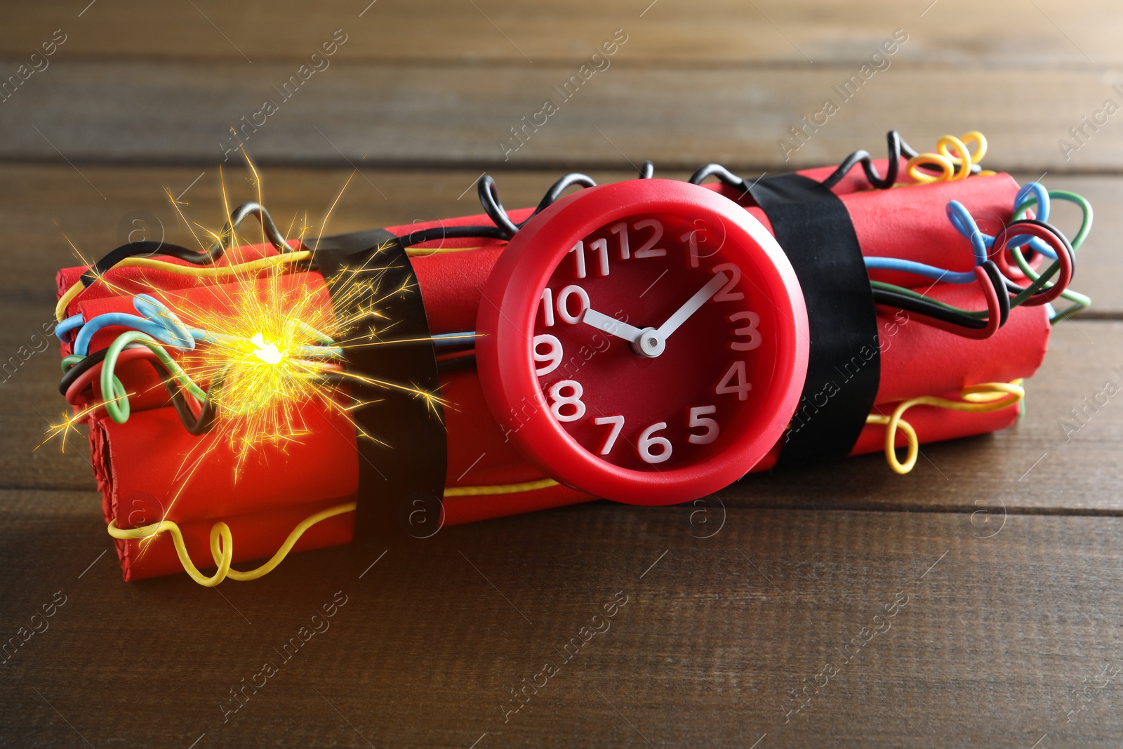 Image of Dynamite time bomb with burning wires on wooden table