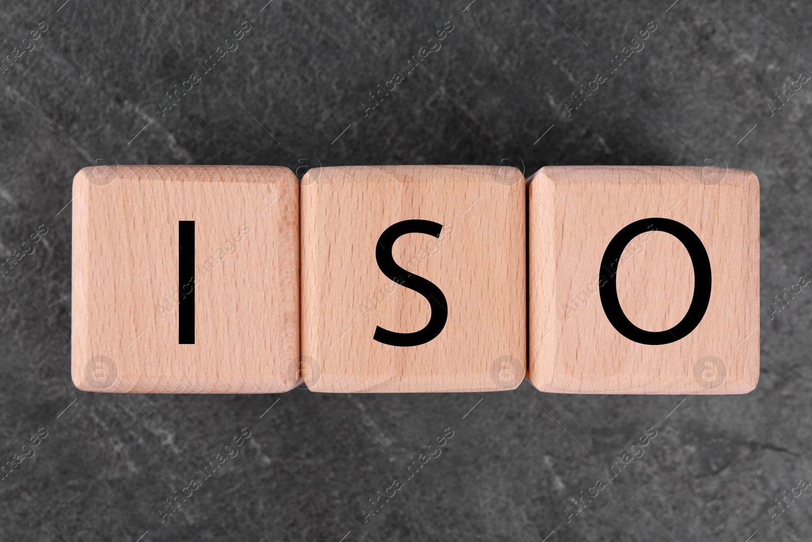 Photo of International Organization for Standardization. Cubes with abbreviation ISO on gray textured table, top view