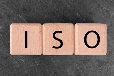 International Organization for Standardization. Cubes with abbreviation ISO on gray textured table, top view