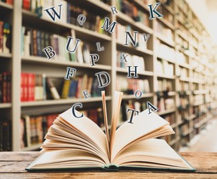 Open book with letters flying out of it in library