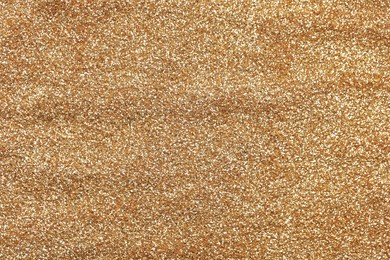 Photo of Beautiful golden shiny glitter as background, top view