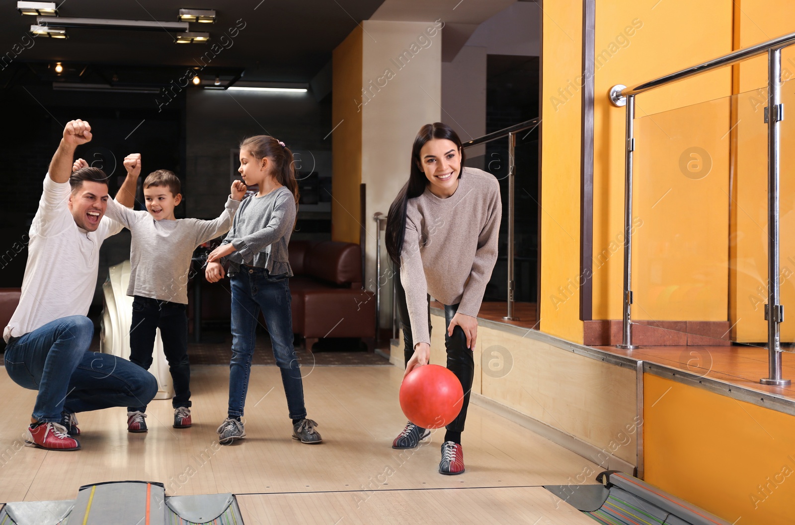 Photo of Happy family spending time together in bowling club