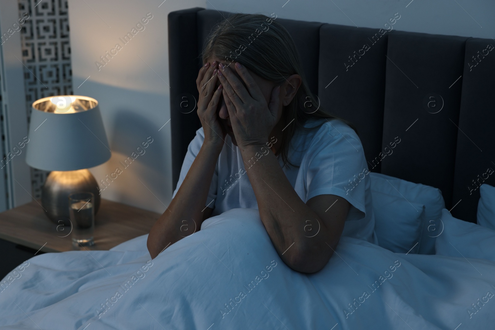 Photo of Woman suffering from headache in bed at night