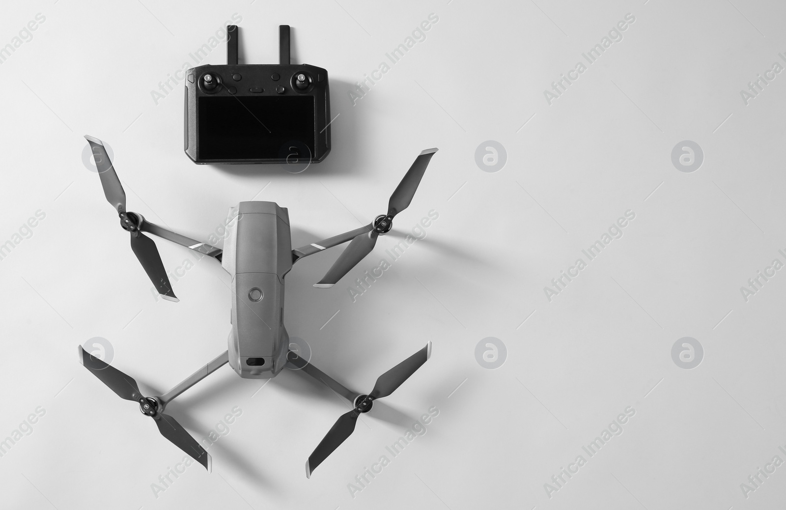 Photo of Modern drone with controller on light background, top view. Space for text