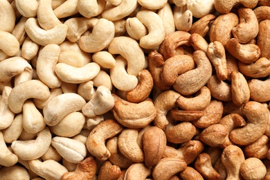 Tasty cashew nuts as background, top view