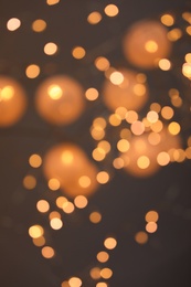 Photo of Blurred view of gold lights on dark background. Bokeh effect