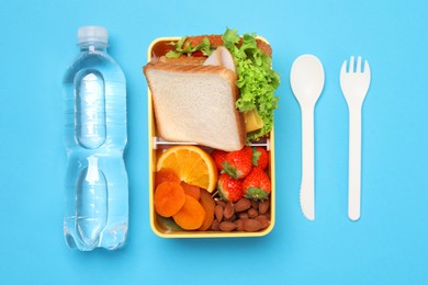Photo of Flat lay composition with tasty food, water and cutlery on light blue background. School dinner