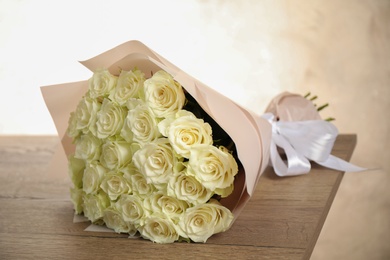 Photo of Luxury bouquet of fresh roses on wooden table