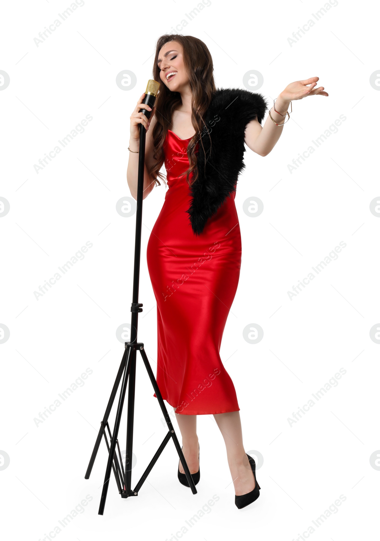 Photo of Beautiful young woman in stylish red dress with microphone singing on white background