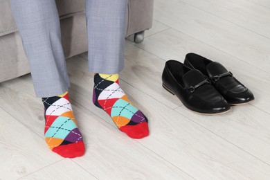 Photo of Man wearing colorful socks indoors, closeup view