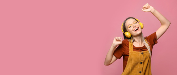 Image of Young woman listening to music with headphones on pink background, space for text. Banner design