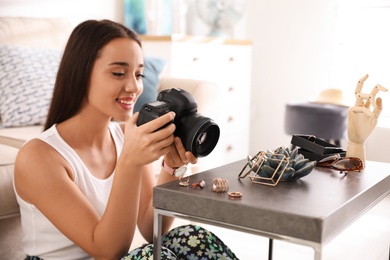 Photo of Young photographer taking picture of jewelry indoors