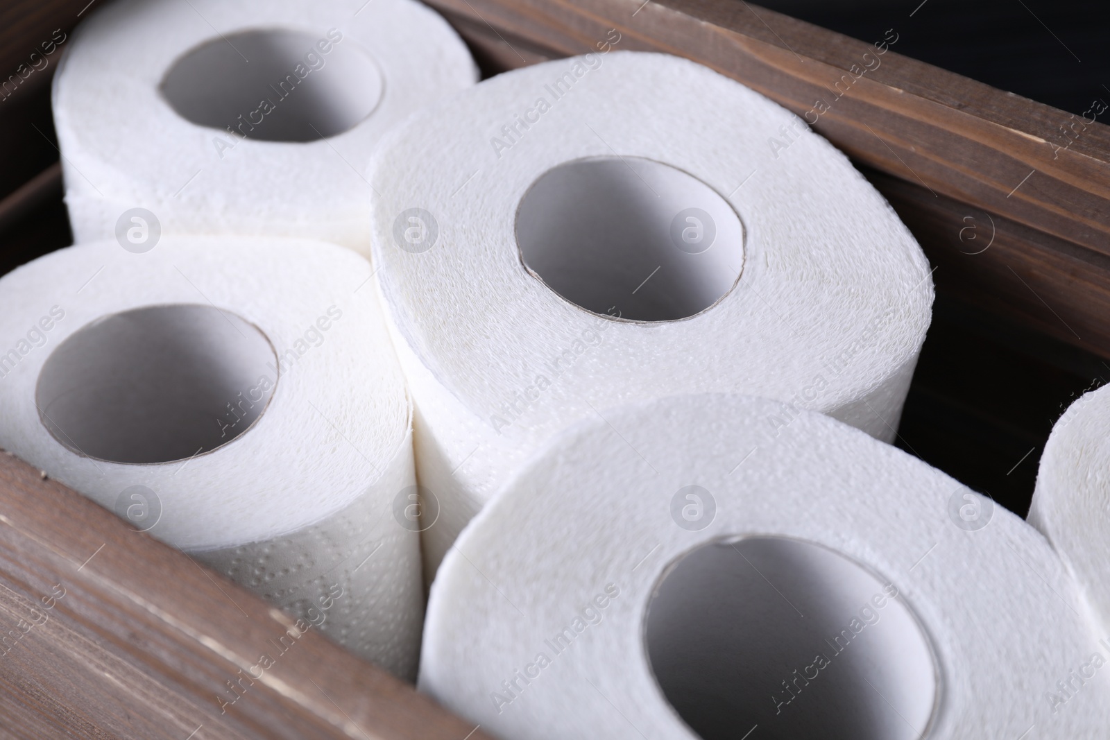 Photo of Many toilet paper rolls in wooden crate, closeup